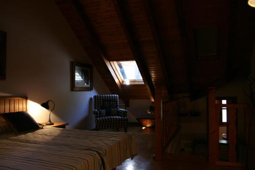 a bedroom with a bed and a window and a chair at San Antón in Benasque