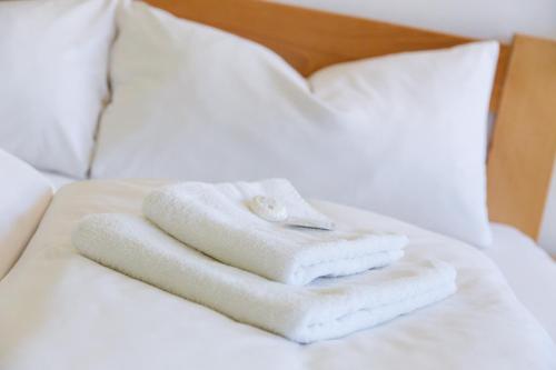 a pile of towels sitting on top of a bed at Pension Kraus in Litomyšl