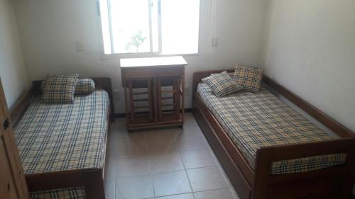 2 camas en una habitación pequeña con ventana en Monoambiente en Montoya, en Punta del Este