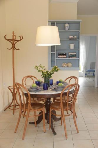 a dining room table with chairs and a lamp at Bakagiannis Apartments in Parga