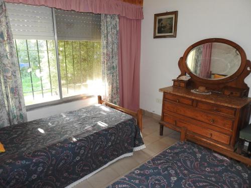 a bedroom with a bed and a mirror and a dresser at La Loberia - Las Grutas in Las Grutas