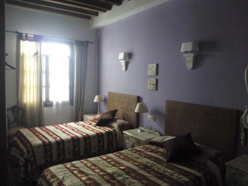 a hotel room with two beds and a window at El Sueño de Lucrecia in Villarrubia de Santiago