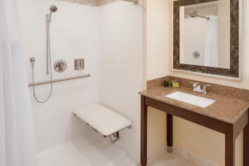a bathroom with a sink and a shower at Westford Regency Inn & Conference Center in Westford