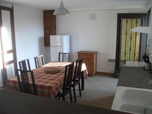 a kitchen with a table with chairs and a refrigerator at gite les chaumeix in Prondines