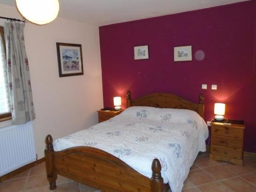 a bedroom with a wooden bed and purple walls at ASpace Holidays in Parthenay