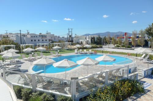 a large swimming pool with umbrellas and chairs at Birikos Hotel & Suites in Agios Prokopios