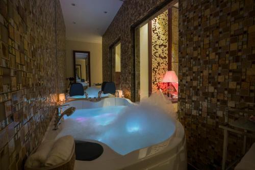 Retaj Hotel Apartments في الخرج: حمام مع حوض كبير في الغرفة