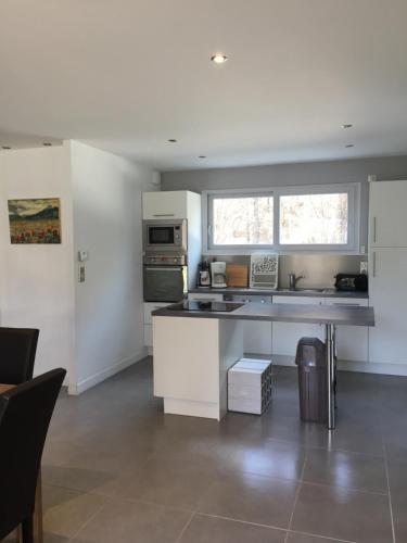 une cuisine avec des armoires blanches et un comptoir dans l'établissement Villa MARIA, à Chambon-sur-Lac