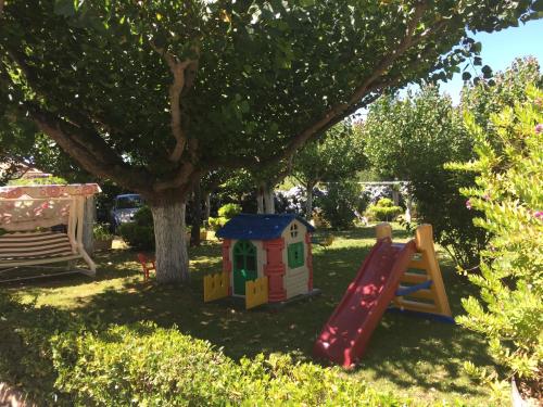 a playground with a slide and a tree at Hotel Florida in A Lanzada