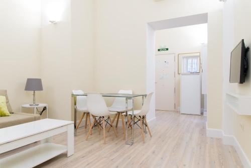 - un salon avec une table à manger et des chaises dans l'établissement Adama Apartamento Turístico, à Cáceres