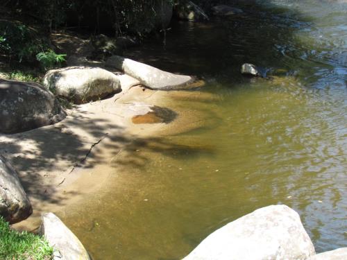 a pool of water with rocks in a river at Eco Chalés Águas Claras in Lumiar