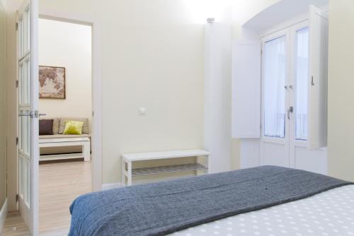 - une chambre blanche avec un lit et une fenêtre dans l'établissement Adama Apartamento Turístico, à Cáceres