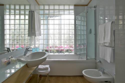 a bathroom with two sinks and a tub and a window at Hotel Spadari Al Duomo in Milan