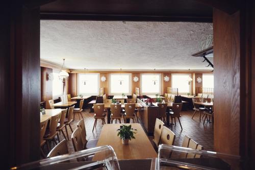 een restaurant met houten tafels, stoelen en ramen bij Boutique Hotel Kokoschinski in Feldberg