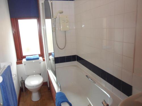 uma casa de banho com uma banheira, um WC e um chuveiro em The Exeter em Glasgow