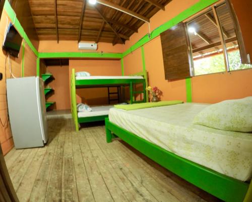 a bedroom with two beds and a bunk bed at Cabañas Ecoturisticas Y Club Gaira Tayrona in Santa Marta