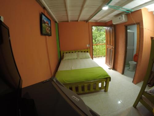 a small bedroom with a bed in a room at Cabañas Ecoturisticas Y Club Gaira Tayrona in Santa Marta