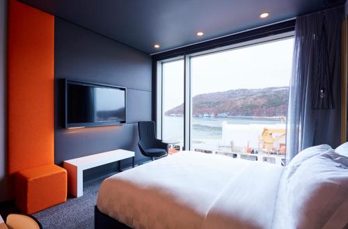 a hotel room with a bed and a large window at Alt Hotel St. John's in St. John's