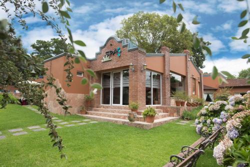 a large brick house with a yard at Don Numas Posada & Spa in San Lorenzo