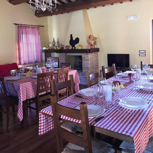 a dining room with tables and chairs with red and white tablecloths at Villa Santa Maria Deruta in Deruta
