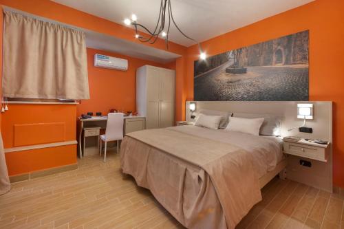 a bedroom with orange walls and a bed and a desk at B&B Sorrento Queen in Sorrento