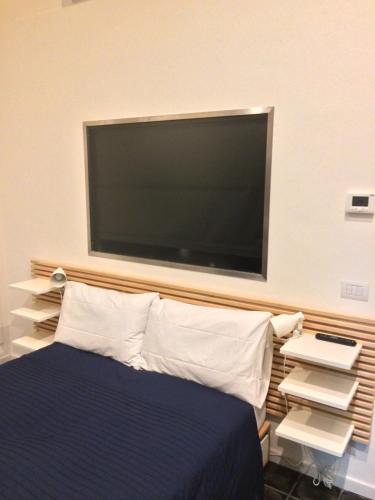 a flat screen tv above a bed in a room at Via Braschi Sessantotto in Cesena