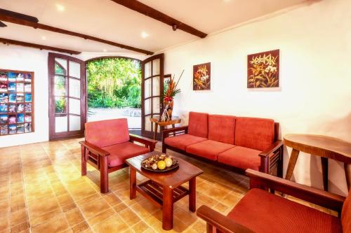 a living room with a red couch and chairs at Atlantis Dive Resort Dumaguete in Dauin