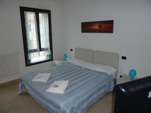 a bedroom with a bed with two towels on it at Casa Cuore - Love Pets - Fronte Ospedale Sacro Cuore in Negrar