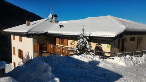 a house covered in snow with a pile of snow at Il Cardo Trentino in Bedollo