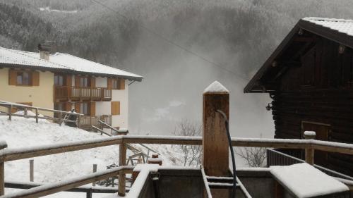 a snow covered yard with a house in the background at Il Cardo Trentino in Bedollo