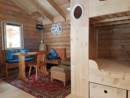 ein Zimmer in einem Blockhaus mit einem Tisch und einem Bett in der Unterkunft Der Nesselbacher in Schmallenberg