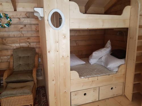 a cabin with two bunk beds and a chair at Der Nesselbacher in Schmallenberg