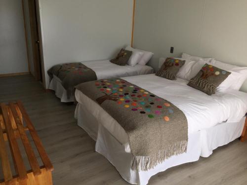 Mangata Hotel Low Cost في كاسترو: غرفة بسريرين عليها ورد