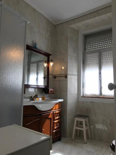 a bathroom with a sink and a mirror and a stool at Excellent apartment in Lisbon in Lisbon