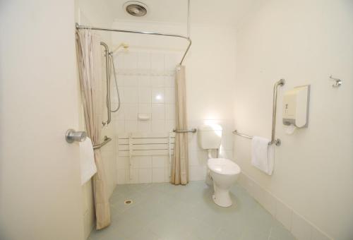a bathroom with a toilet, shower, and sink at Sandown Heritage Motel in Noble Park