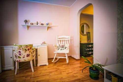 Cette chambre comprend une chaise, un bureau et un miroir. dans l'établissement Mozaic Home, à Bucarest