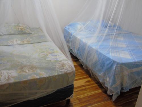two beds sitting next to each other in a room at Hostal Villas Mexico in San Juan del Sur