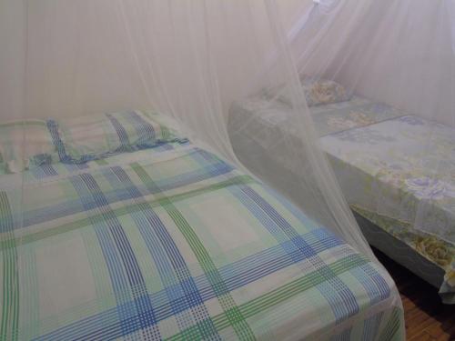 a bedroom with a bed with a mosquito net at Hostal Villas Mexico in San Juan del Sur