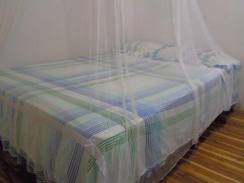 a bed with a mosquito net on top of it at Hostal Villas Mexico in San Juan del Sur