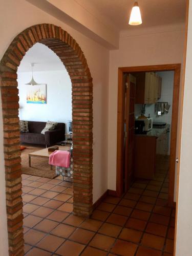 a brick archway in a room with a living room at Casa Sol e Mar em Porto Covo in Porto Covo