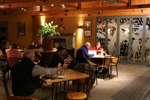 a group of people sitting at tables in a restaurant at Stumpers Hotel in Hokitika
