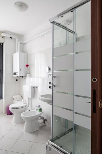 a bathroom with a toilet and a glass shower door at Bed & Breakfast Cesarina in Bologna