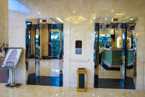 a lobby with a glass elevator in a building at Ocean Haven Hotel in Da Nang