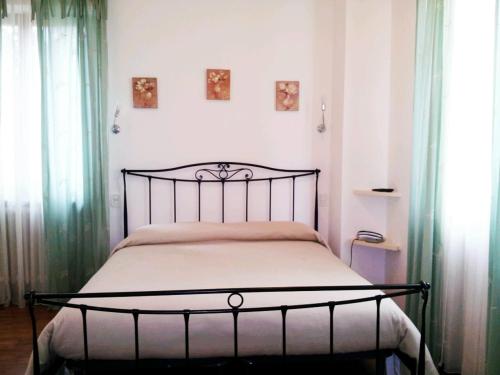 a bed in a bedroom with two windows at Luconi Affittacamere in Iesi