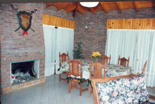 sala de estar con chimenea, mesa y sillas en Juana Pinamar en Ostende