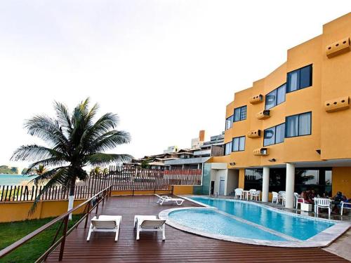 ein Hotel mit einem Pool neben einem Gebäude in der Unterkunft Atlântico Flat 110 in Natal