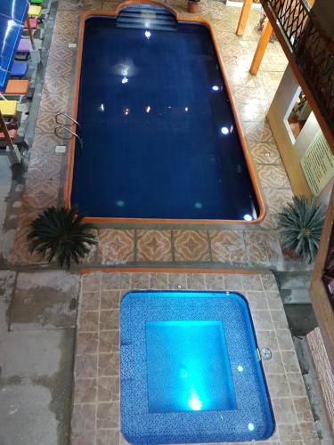 a swimming pool with a blue water in the middle at Hotel Mediterraneo in Canoa