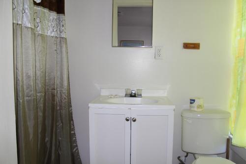 a bathroom with a sink and a toilet and a mirror at Surf Villa Hotel in Ocean City