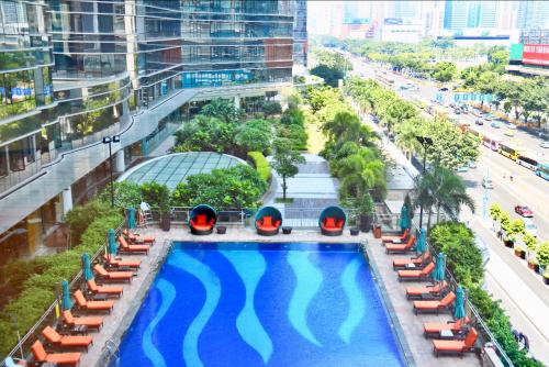 an overhead view of a swimming pool with chairs and a street at Fraser Suites Guangzhou in Guangzhou