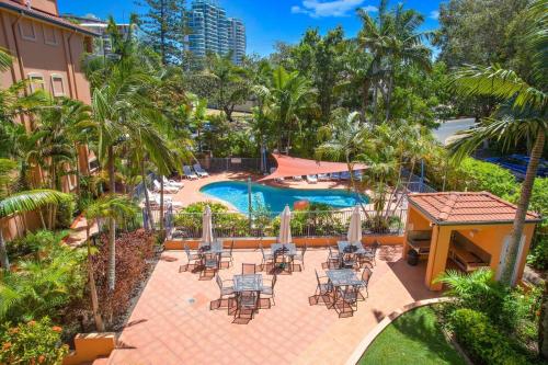 a patio area with chairs, tables, and umbrellas at Bella Mare Coolangatta Beachside Apartments in Gold Coast